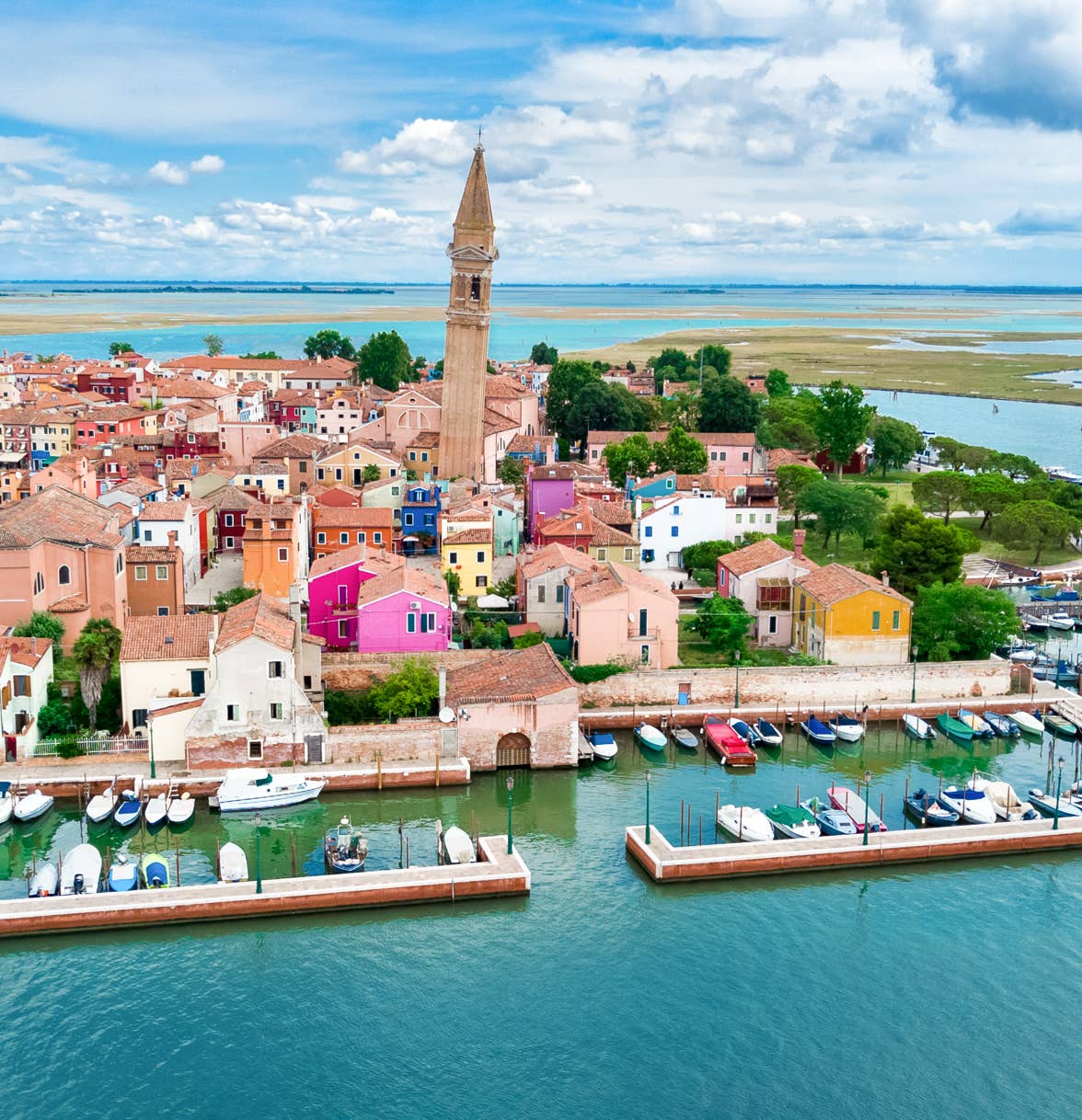 Uno scorcio aereo dell'incantevole isola di Burano, con vista sulle caratteristiche case colorate e il suo caratteristico campanile pendente.
